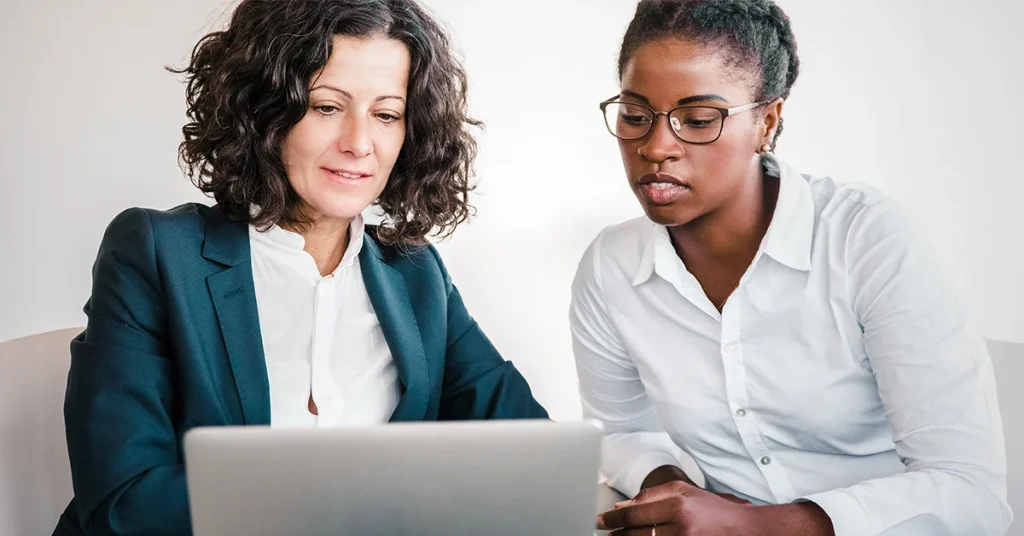 Two nurse educators reviewing federal funding resources online