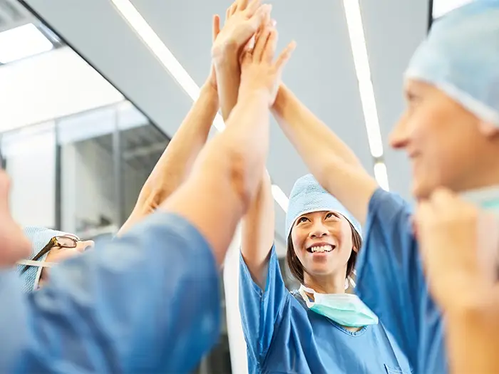 Group of nurses giving high fives.