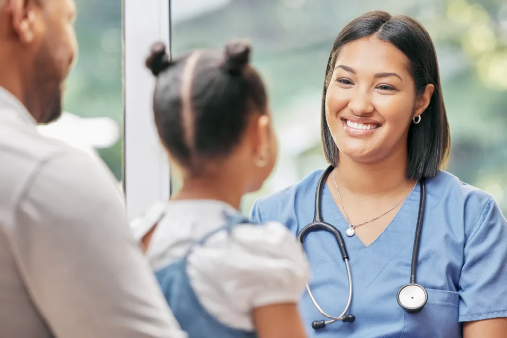 A nurse talking to a child patient and parent during a clinical visit