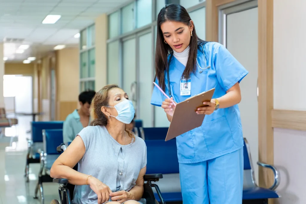 Young nurse talking to patient in wheelchair