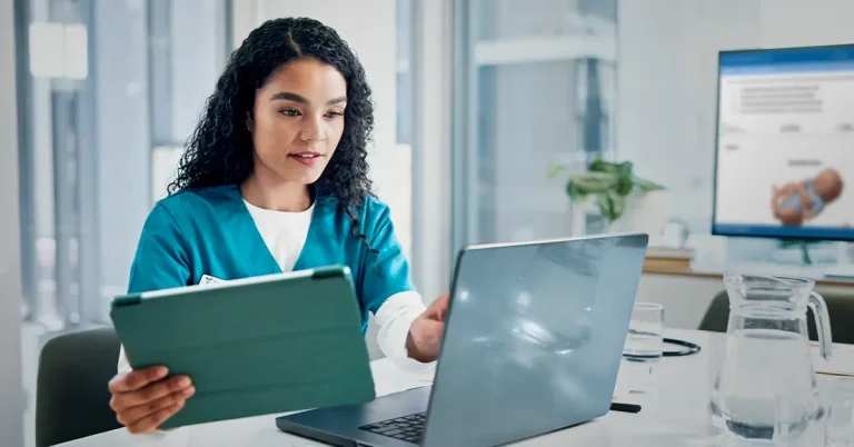 Nurse creating an assignment on laptop